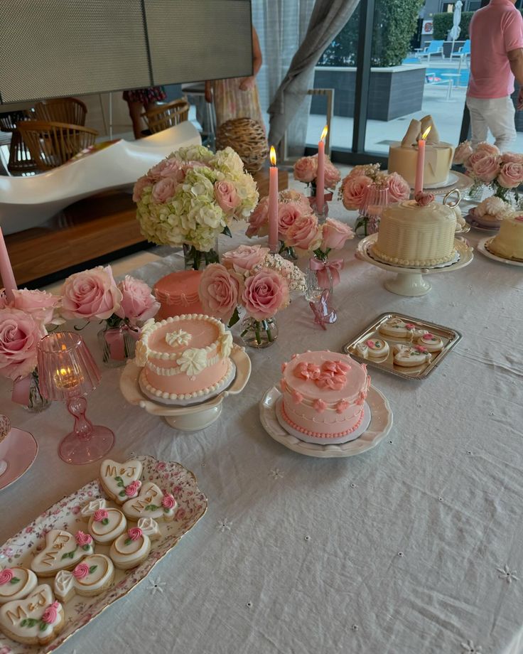 a table topped with lots of cakes and cupcakes