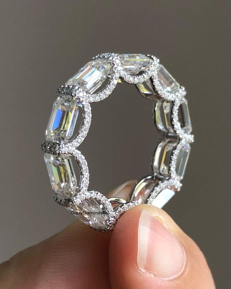 a person holding a diamond ring in their hand