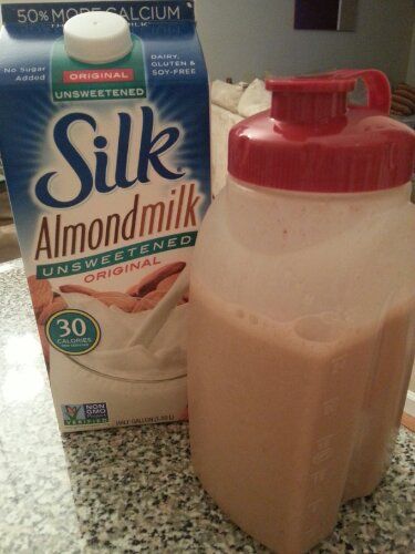 a bottle of milk next to a carton of almond milk on a counter top