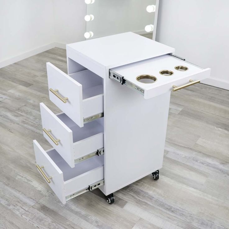 a white vanity with three drawers and a mirror on the wall above it, in a room