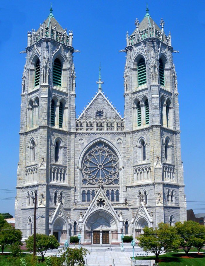 the large cathedral has two towers on it's sides and is surrounded by greenery