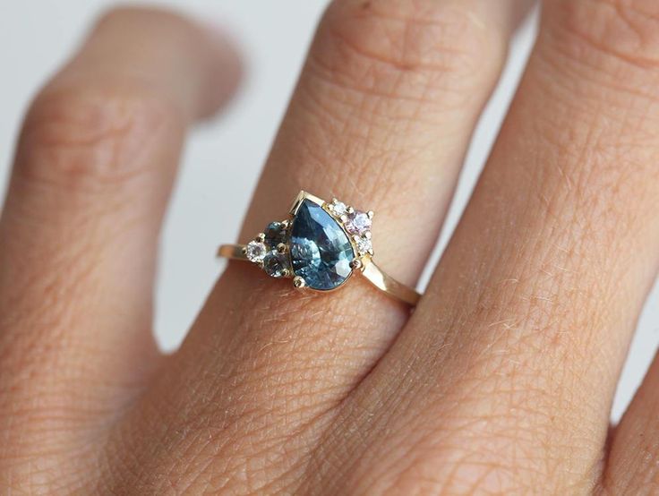 a woman's hand with a blue and white diamond ring