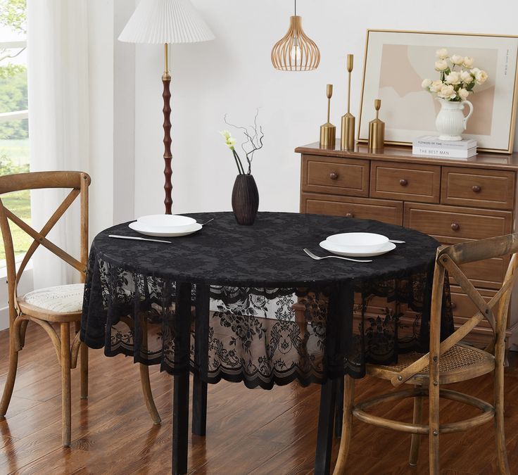 a dining room table with two chairs and a vase on top of it in front of a window