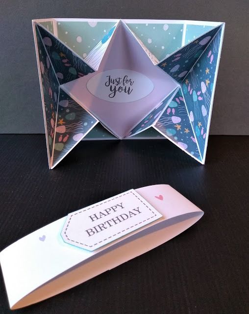 an origami birthday card and knife on a table with a greeting card in it