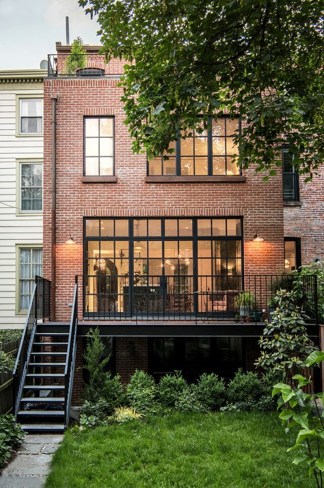 an apartment building with stairs leading up to the upper level and second story windows on one side