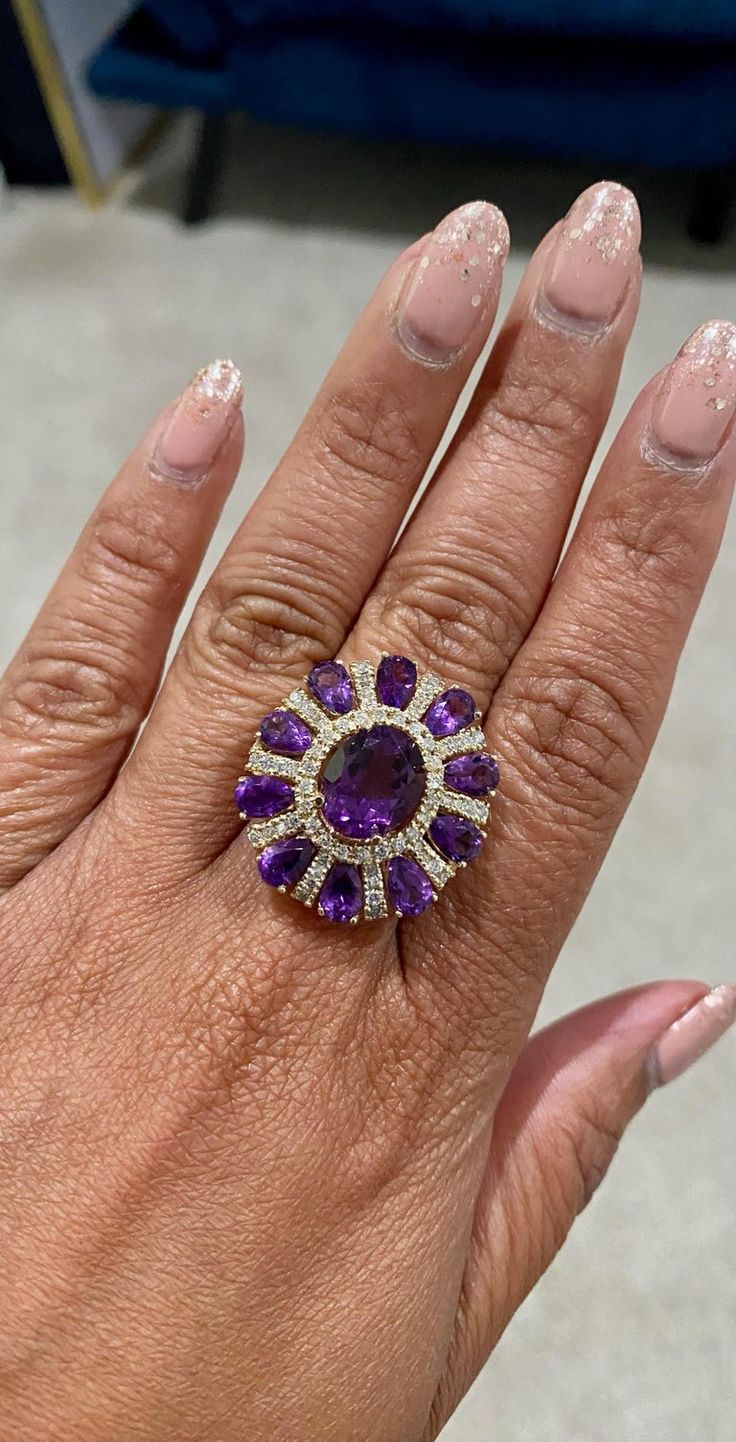 This ring has a Natural Oval Cut Amethyst that weighs 3.28 carats and Natural Pear Cut Amethysts that weigh 3.28 carats. It also has Natural Round Cut Diamonds that weigh 1.06 carats. The total carat weight of the ring is 8.28 carats. Curated in 14 Karat Yellow Gold. The ring is a size 7 and can be re-sized at no additional cost. Amethyst Cocktail Ring, Yellow Gold Cocktail Ring, Gold Cocktail Ring, Gold Cocktail, Pear Cut, Cocktail Ring, Round Cut Diamond, Cocktail Rings, Free Jewelry