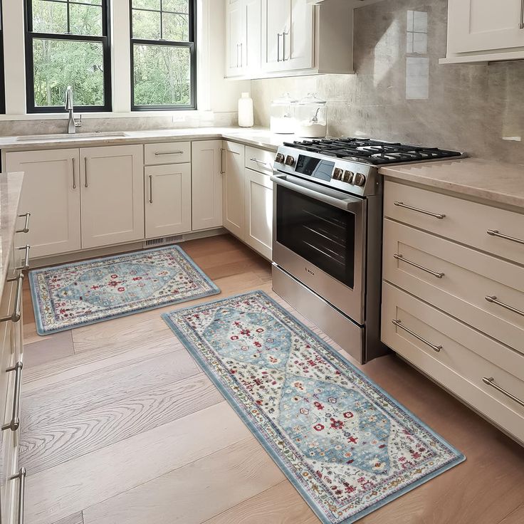 two rugs are on the kitchen floor in front of an oven and stove top