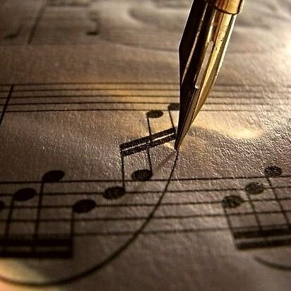 a pen sitting on top of musical notes