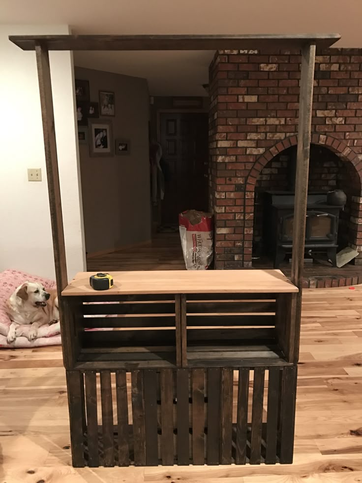 a dog laying on the floor in front of a fire place with a fireplace behind it