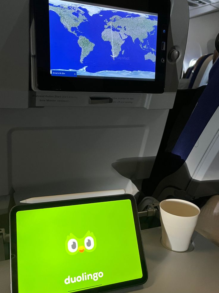 a laptop computer sitting on top of a desk next to a cup and saucer