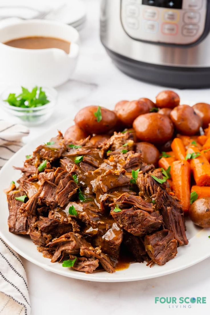 a white plate topped with roast beef and carrots next to an instant pressure cooker