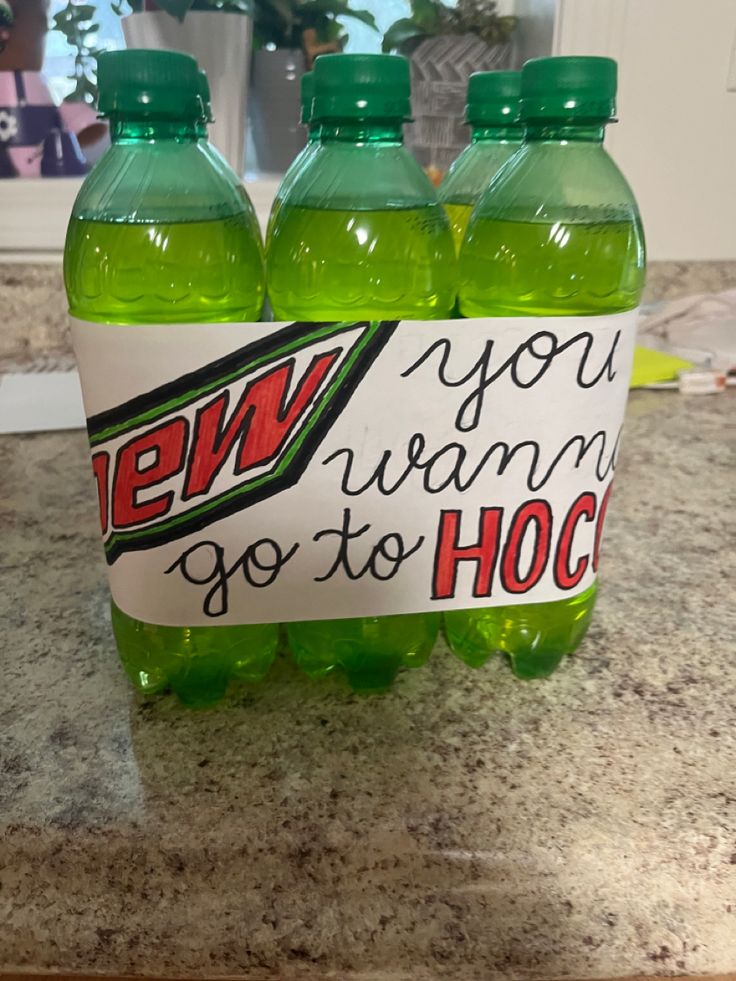 three green soda bottles sitting on top of a counter next to a sign that says new you wanna go to hoc