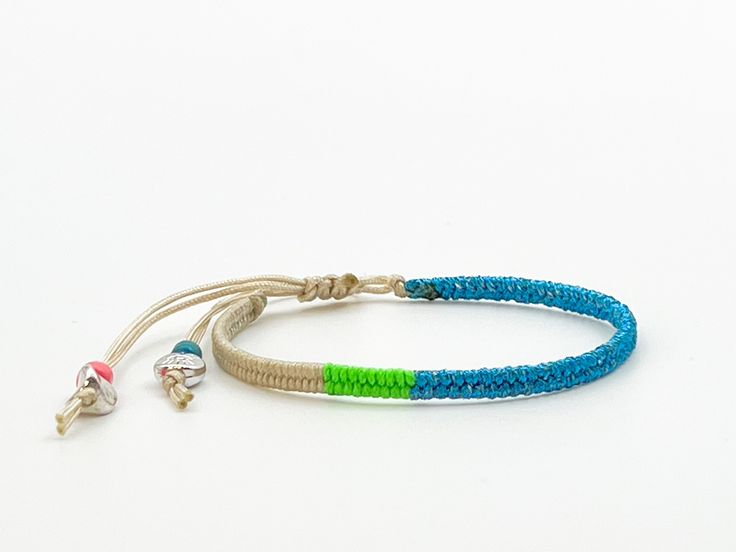 This beige bracelet with glitter blue yarn is comfortable to wear and lightweight around the wrist with adjustable sliding knot closure so fits most sizes both women, men and children. It harmonizes with every outfit, every occasion, also perfect as a gift for your loved ones. Wrapped length 13cm, extension braided length 11cm, width 0.4cm Designed and made in a smoke free - pet free environment.  All our products are nickel free and kind to the skin.  Each bracelet is unique and handmade, there Adjustable Blue Beaded Bracelets In Hippie Style, Adjustable Blue Beaded Bracelets Hippie Style, Adjustable Blue Beaded Hippie Bracelets, Adjustable Blue Beaded Bracelets, Hippie Style, Blue Bohemian Friendship Bracelets For Summer, Bohemian Blue Friendship Bracelets For Summer, Green Bohemian Braided Bracelets With Adjustable Length, Blue Beaded Bracelets With Adjustable Cord For Festival, Bohemian Blue Friendship Bracelets With Adjustable Length