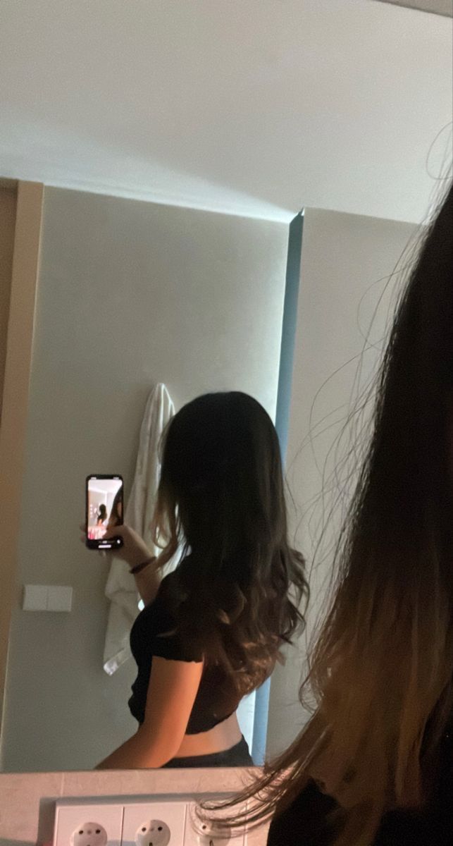 a woman taking a selfie in front of a mirror