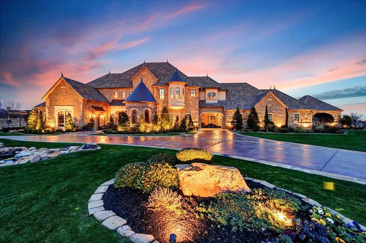 a large house with lots of windows and lights on it's front lawn area