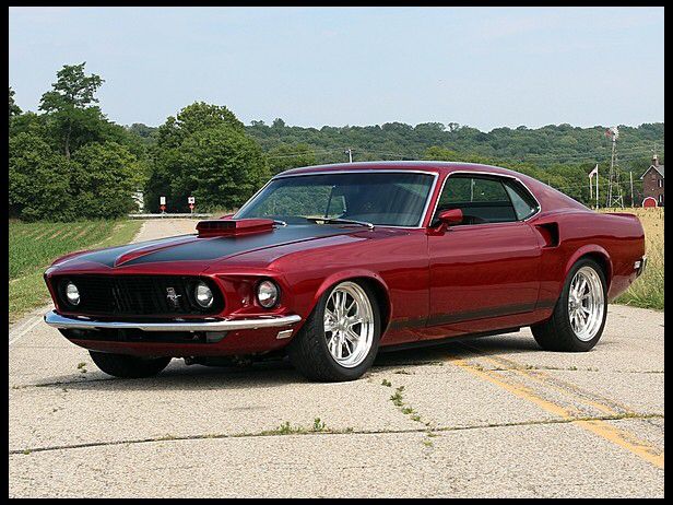 a red muscle car parked in a parking lot