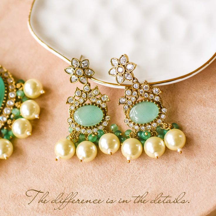 Elevate your style with our Mughal masterpiece - where heritage meets modern elegance! Crafted with precision and elegance, this set captures the opulence of Mughal aesthetics, combining vibrant pumpkin green beads and sparkling CZ stones along with intricately designed mala accompanied by dangling cream-colored pearls, this set epitomizes grace and sophistication, making it a statement piece for any occasion. The set includes a mala and a pair of earrings. Please click on the video for a detail Elegant Kundan Necklace With Emerald Stone Work, Elegant Emerald Kundan Necklace With Stone Work, Elegant Kundan Emerald Necklace For Festive Occasions, Elegant Emerald Kundan Necklace For Festive Occasions, Elegant Stone Work Chandbalis For Diwali, Fusion Style Festive Jewelry Sets With Elegant Design, Elegant Green Kundan Necklace For Festive Occasions, Elegant Jeweled Jhumkas For Diwali, Elegant Jeweled Chandbalis For Diwali