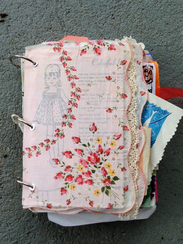 an open notebook covered in fabric and flowers