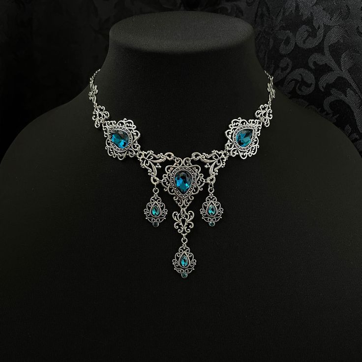 "This romantic necklace features richly detailed antiqued silver filigrees, scrolls and beaded accents. Adorned with sparkling dark aqua glass crystals, its breath taking design will add Victorian elegance to your outfits. Decorated portion is 8 1/4\" wide and 2 3/4\" tall in the very center.  Necklace length is adjustable with soldered stainless steel cable chain, lobster clasp and extender. If you would like a different length, please send us a message. Matching headpiece and earrings are listed separately in our store. If you don't see items with a color you want, feel free to ask about availability." Victorian Elegance, Antique Silver Necklace, Dark Aqua, Romantic Necklace, Victorian Goth, Aqua Glass, Gothic Victorian, Dark Sapphire, Costume Necklaces