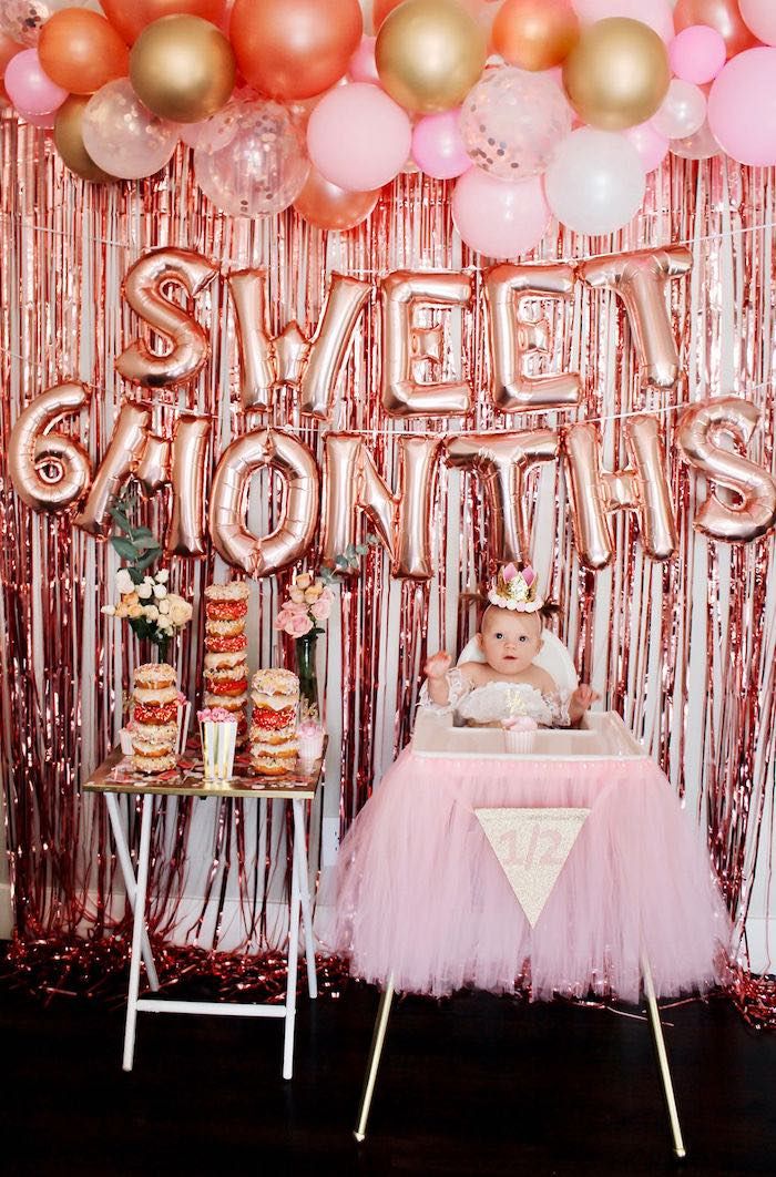 a baby in a pink tutu surrounded by balloons and streamers with the words sweet moments on it