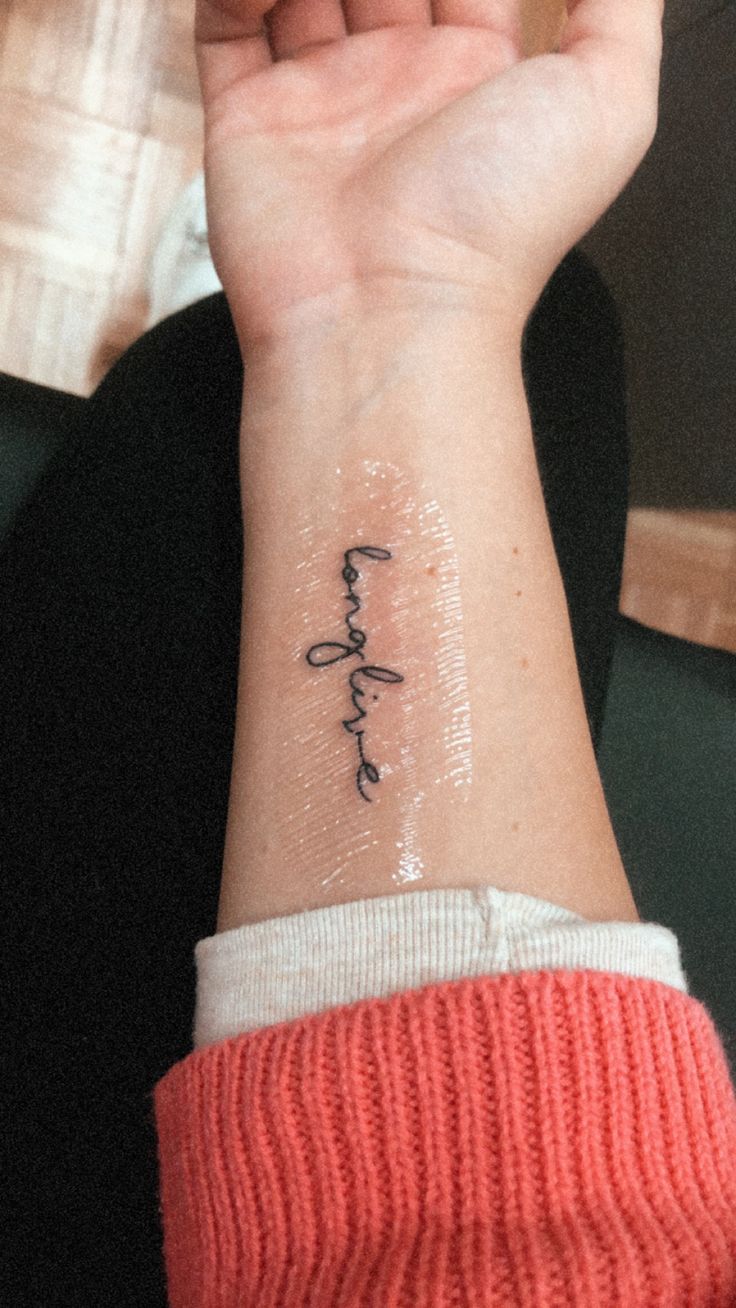 a woman's wrist with the word faith written in cursive writing on it