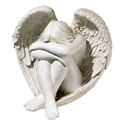 a statue of an angel sitting in a basket