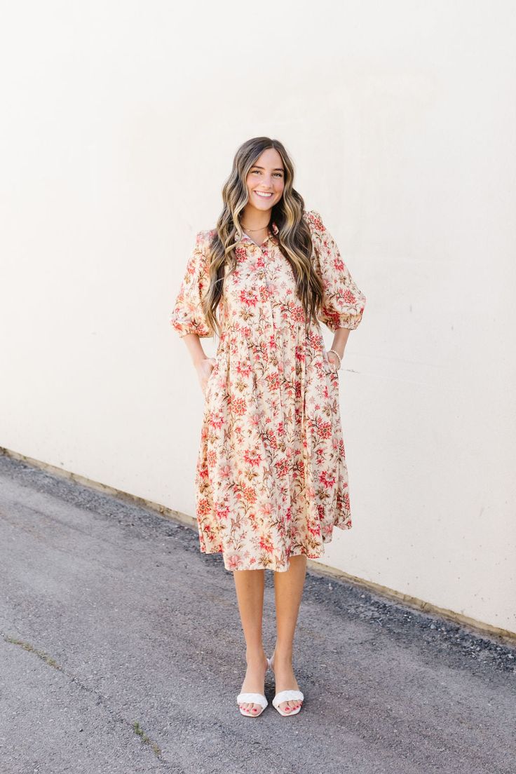 Introducing the Lindley Midi, a luxurious cream shirt dress adorned with delicate pink florals. This midi dress features a button-up design, 3/4 sleeves, and convenient pockets. Make a statement in this elegant and exclusive piece. Fits true to size. Model is wearing a small and is 5'5". Plus model is wearing a 1X and is 5'7". Size Chart Length Bust Waist S 41" 35" 35" M 42" 38" 38" L 42" 40" 40" XL 43.5" 42" 42" 1x 44" 46" 46" 2x 44" 48" 48" 3x 44" 52" 52" *Measurements are approximate and are Modest Ditsy Floral Midi Dress For Garden Party, Feminine Cream Midi Dress For Garden Party, Modest Floral Dress For Spring, Feminine Mid-length Floral Dress, Spring Midi Dress With Pockets And Half Sleeves, Modest Ditsy Floral Print Dress For Daywear, Casual Floral Print Dress With 3/4 Sleeves, Modest Ditsy Floral Dress For Daywear, Feminine Midi Dress With Floral Print