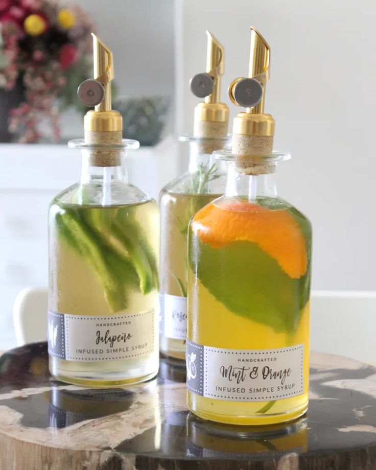 two bottles filled with liquid sitting on top of a wooden table