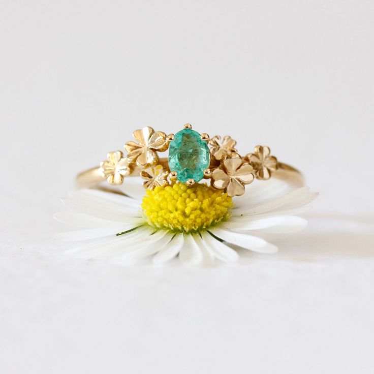 Emerald Clover Ring - Silver/Gold - emerald ring, may birthstone ring, engagement ring, lucky ring, promise ring, irish engagement ring, gold emerald ring, plant ring, green ring, graduation gift, gift for bridesmaid, exam gift.  Our beautiful clover ring features an emerald nestled amongst the leaves.  The setting allows gorgeous green hues of light to radiate from the gemstone. This clover ring is part of our talisman collection, designed to bring the wearer faith, hope, love and luck. Handmad Green Oval Sapphire Promise Ring, Green Emerald-cut Sapphire Wedding Ring, Green Emerald Cut 14k Gold Cluster Ring, Emerald Cut Green Cluster Ring In 14k Gold, Yellow Gold Flower Promise Ring For May Birthstone, Emerald Cut Green Sapphire Wedding Ring, 14k Gold Emerald Ring For Promise, May Birthstone, Heirloom Green Sapphire Ring For May Birthstone, 14k Gold Emerald Promise Ring, May Birthstone