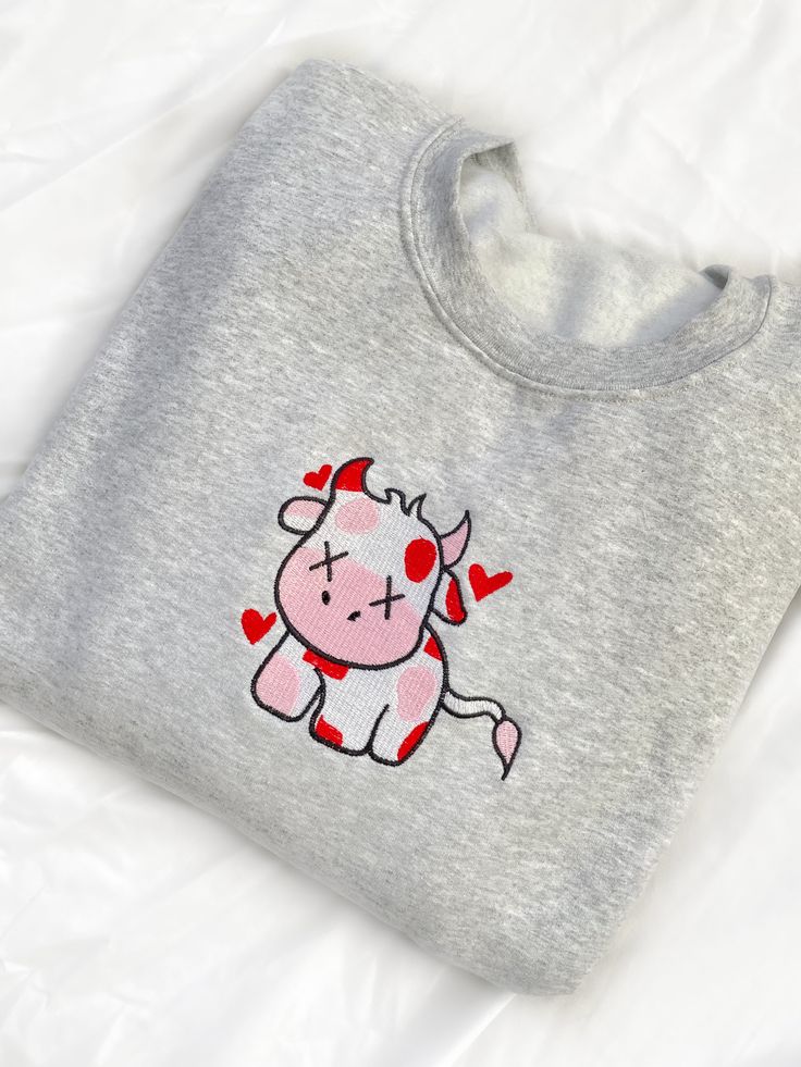 Look sweet and comfy in our Valentine Cow Crewneck Sweatshirt. This sweatshirt features long sleeves, a crew neckline, and beautiful front embroidery. The Unisex Sizing makes the sweatshirt run slightly larger than your average sweatshirt for women. Most men find their normal size to be more snug. If you want a slightly looser fit, size up one size. Please check out our size chart for measurements to ensure an accurate fit. PLEASE BE SURE TO INPUT YOUR CORRECT SIZE/COLOR + SHIPPING ADDRESS. We w Trendy Long Sleeve T-shirt With Embroidered Logo, Trendy Long Sleeve T-shirt With Embroidered Graphics, Cute Long Sleeve T-shirt With Embroidered Text, Trendy Long Sleeve T-shirt With Embroidered Text, Cute Embroidered Logo Sweatshirt For Streetwear, Trendy Long Sleeve Top With Embroidered Graphics, Gray Fleece Sweatshirt With Crew Neck, Casual Long Sleeve T-shirt With Embroidered Logo, Casual Long Sleeve T-shirt With Embroidered Graphics