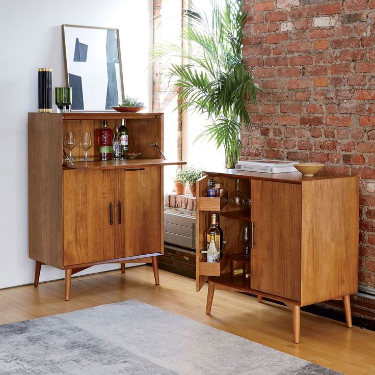 a living room with a brick wall and wooden furniture on the floor next to a potted plant