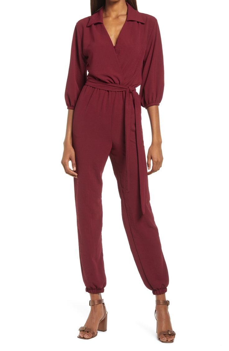 The jumpsuit trend is, well, hopping, and this option, styled with an easy tied waist and elastic cuffs, is a winning way to wear the look. 58" length; 30" inseam; 10" leg opening (size Medium) Front button-and-loop closure Surplice V-neck with spread collar Long sleeves Elastic cuffs and waist Front slant pockets Removable tie belt Partially lined 100% polyester Hand wash, line dry Made in the USA Women's Clothing Long Sleeve Solid Jumpsuit With Tie Waist, How To Style Jumpsuit, Chic V-neck Jumpsuits And Rompers With Button Closure, Solid V-neck Jumpsuit With Buttons, Elegant V-neck Jumpsuit With Button Closure, Solid V-neck Belted Jumpsuit, Jumpsuit For Wedding Guest, Coverall Jumpsuit, Formal Jumpsuit