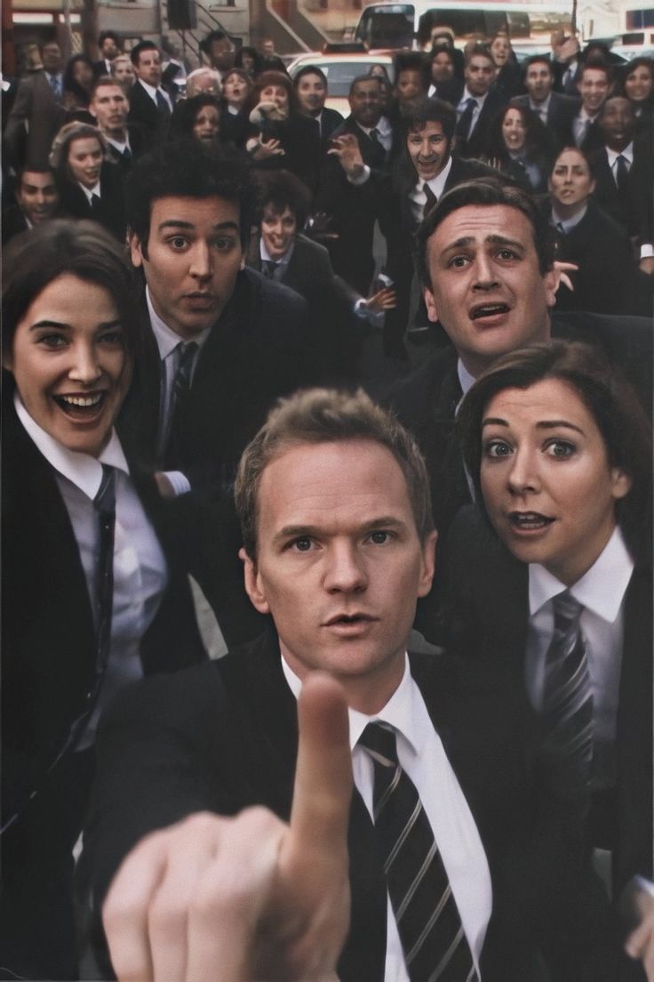 a group of people in suits and ties pointing at the camera