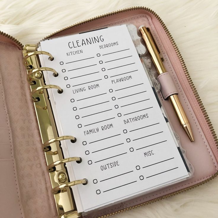 a pink planner with a pen on top of it