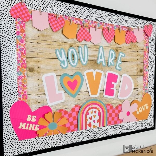 a wooden sign that says you are loved with hearts and buntings on it