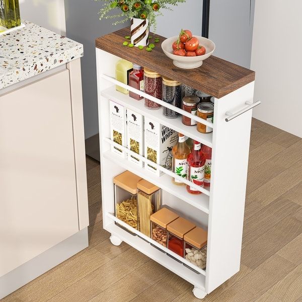 a white kitchen cart with spices and condiments on it next to a counter