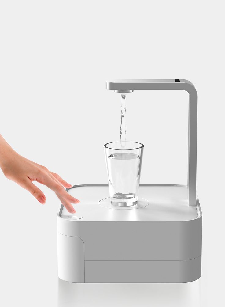 a person's hand reaching for a glass of water on top of a machine