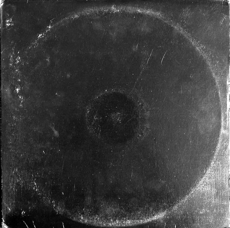 an old black and white photo of a circular object in the middle of it's frame