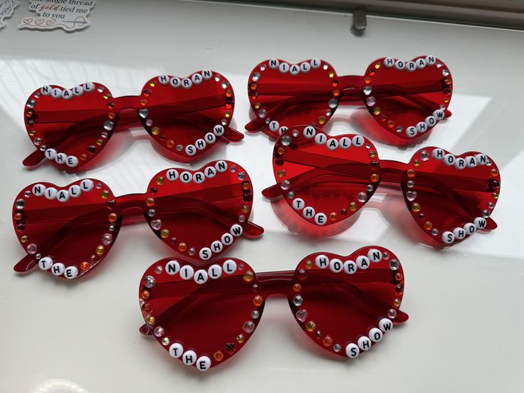 Hand decorated 'Niall Horan The Show' love heart glasses 💗 (type standard for this option) Colours available: Dark pink Purple Light pink Red Blue Black if you're worried about the beads falling off the glasses - don't 🤣 (watch the video) Arms of the glasses may be stiff when opening but they will fully open with care *design subject to change at anytime - no two glasses will be the same* All glasses are hand decorated so will be slightly different than the photos.  If you have any questions, Heart Sunglasses Decorated, Bead Heart Glasses, Decorated Heart Glasses, Heart Glasses With Beads, Heart Glasses Aesthetic, Glasses With Beads, Love Heart Glasses, Cherub Baby, Beaded Glasses