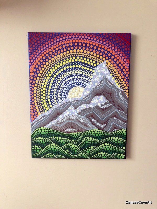 a painting hanging on the wall with a clock in front of it and an image of a mountain