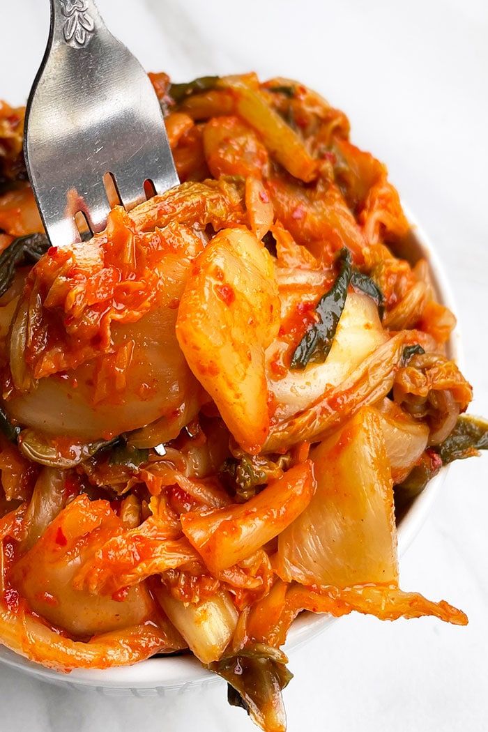 a white bowl filled with food and a fork sticking out of the top of it