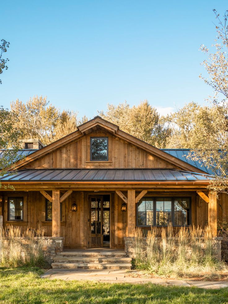 a large wooden house sitting on top of a lush green field