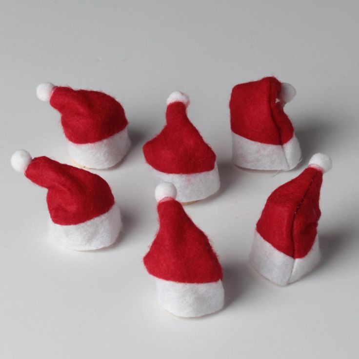 six red and white santa hats sitting on top of a table next to each other