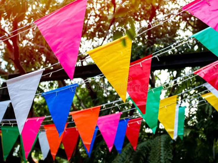 colorful flags hanging from clothes line with trees in the background royalty images and clippings