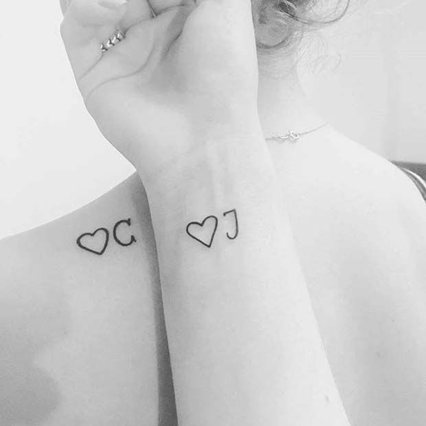 a woman with two hearts on her arm and one has a small heart tattoo on the wrist