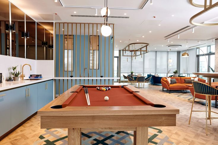 a pool table in the middle of a room with chairs and couches around it