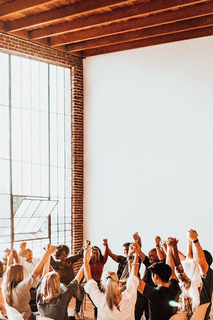 a group of people standing around each other holding their hands up in front of them