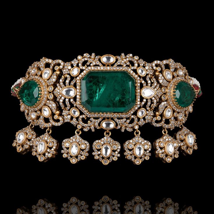 Indulge in luxury, embrace elegance and experience the allure of Kanwal Set - where every piece tells a story of timeless beauty and unparalleled craftsmanship! Dazzle and delight with every step wearing our breathtaking jewelry set featuring a mesmerizing combination of CZ stones with its unparalleled brilliance, polished emeralds evoking the lush beauty of a verdant paradise, and exquisite jadau kundan stones. The set includes a choker and a pair of beautiful earrings. Approximate earrings len Luxury Emerald Jewelry For Formal Occasions, Luxury Hand Set Emerald Necklaces, Formal Bridal Necklace With 17 Jewels And Emerald, Luxury Hand-set Emerald Necklaces, Exquisite Emerald Bridal Necklace, Luxury Diamond Bridal Necklace, Luxury Bridal Necklace With Diamond Gemstone, Luxury Diamond Bridal Necklace With Gemstone, Luxury Diamond Jewelry For Formal Occasions