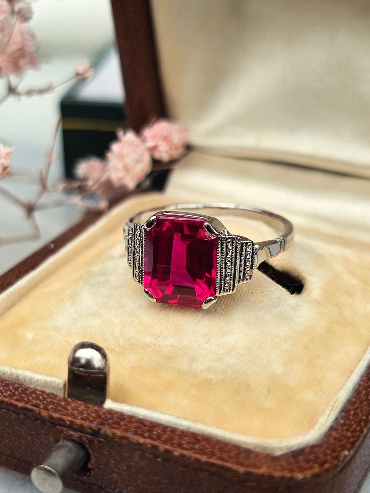 Old Art Deco period ring in 18-carat white gold set with a very pretty synthetic ruby (the top is cabochon-cut while the cylinder head is faceted, which brings a lot of sparkle). Hallmarks present. Dimensions of the Ruby: 9 × 7 mm (approximately 2.90 carats) Weight: 2.55 g Size 50 - US size 5.25 (Resizing possible, not made by the store) Note: small chip on the stone located under one of the 4 claws, barely visible. Delivered with certificate invoice. Sending in a tracked and secure package. Return possible within 14 days. Do not hesitate to contact the store if necessary! Shop link: https://www.etsy.com/fr/shop/EtoileGrenat?ref=seller-platform-mcnav White Gold Set, Art Deco Period, Cylinder Head, Multi Stone Ring, Ruby Ring, Old Art, Multi Stone, Gold Set, Stone Rings