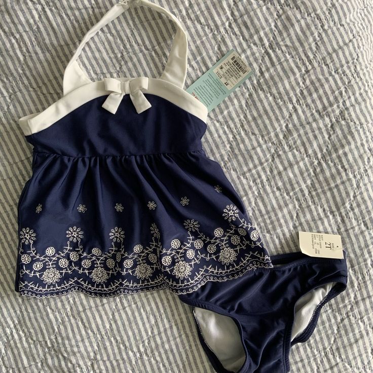 Halter Style Floral 2-Piece Navy Swimsuit Brand New With Tags Size: 2t Tankini With Cute White Flower Embroidery & Bow! $4.99 Shipping When You Bundle 3+ Kids Items! Playful White Sets For Poolside, Cute Spring Tankini For Playwear, White Beach Season Playwear Sets, Summer Beachwear Sets For Playtime, Summer Playtime Beachwear Sets, White Summer Sets For Pool, White Sleeveless Tankini For Playwear, White Sleeveless Playwear Tankini, White Summer Pool Sets